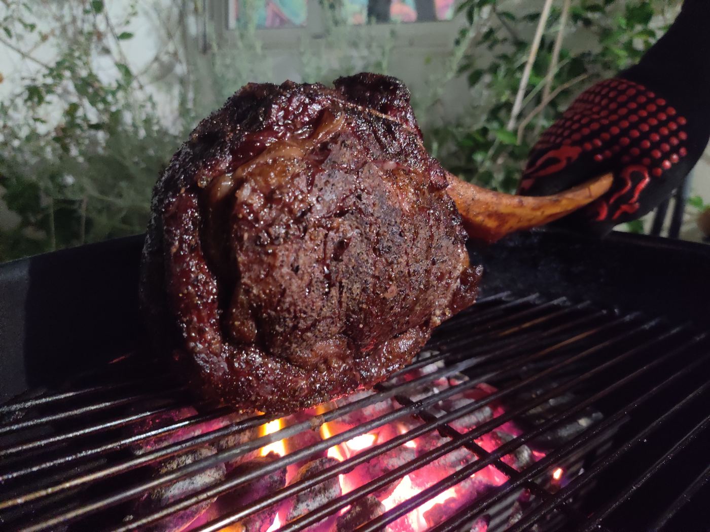Thick tomahawk steak seared and smoking straight off the grill